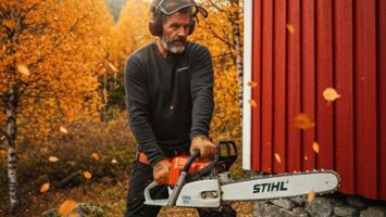 Person bruker Stihl motorsag for vedhogging ved norsk hytte